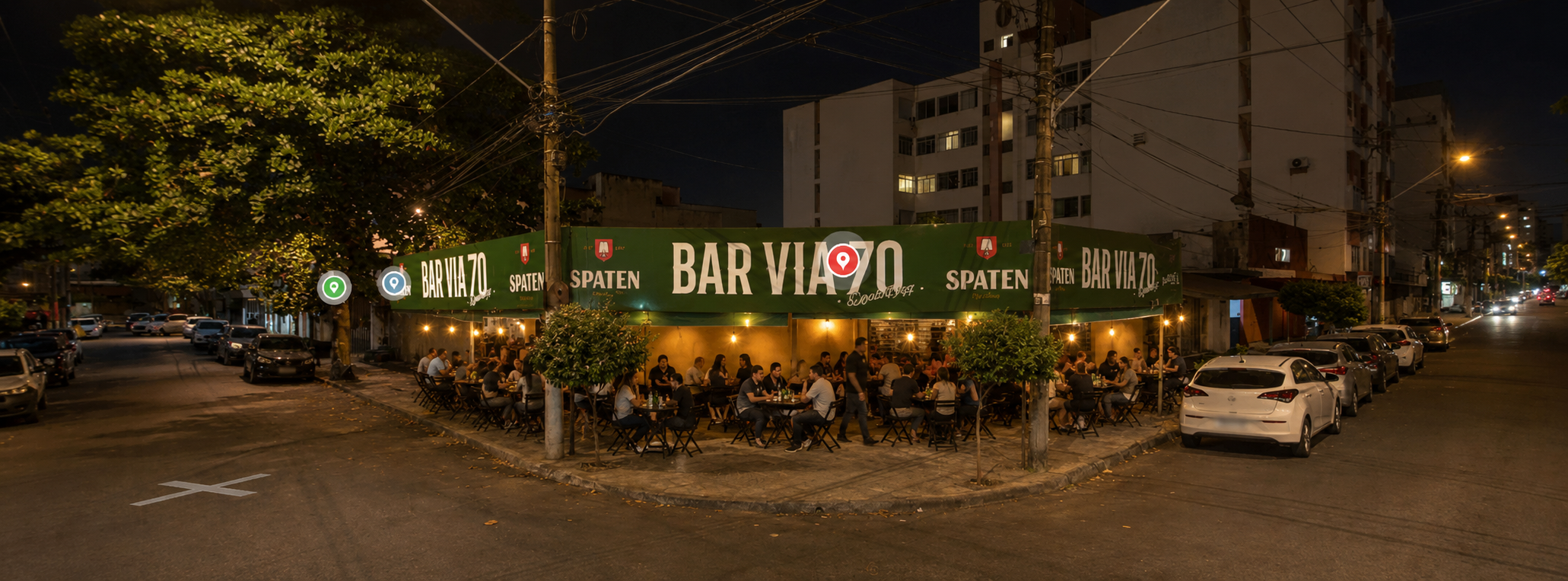 Bar Via 70 à noite com mesas e clientes